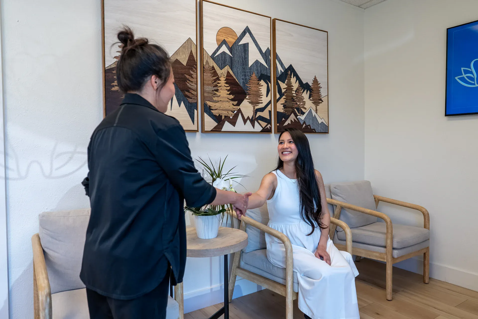A team member greeting a patient in the mountain-inspired reception lounge at Colorado Dental Spa in Golden, CO
