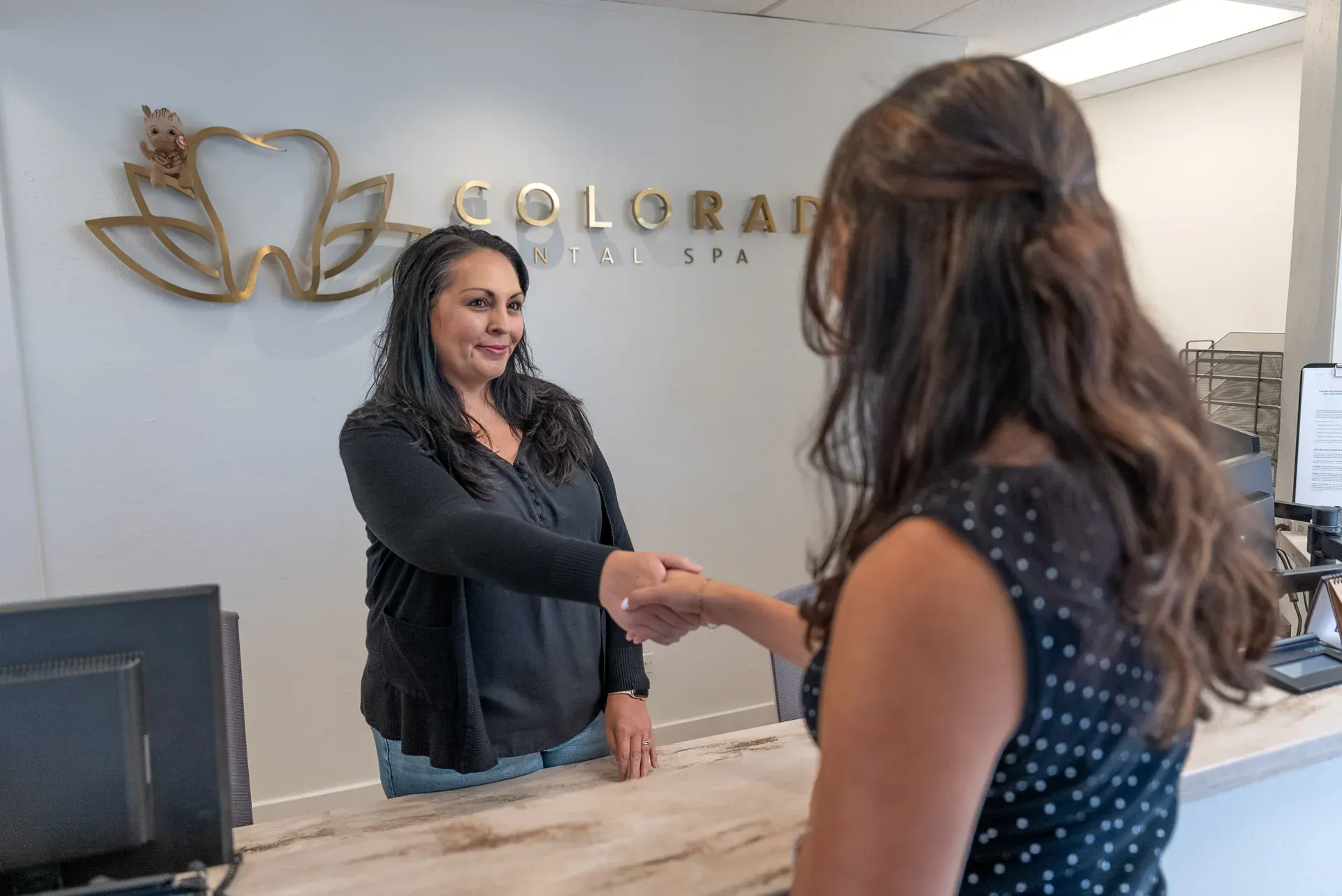 A patient being welcomed at the front desk of Colorado Dental Spa in Golden, CO