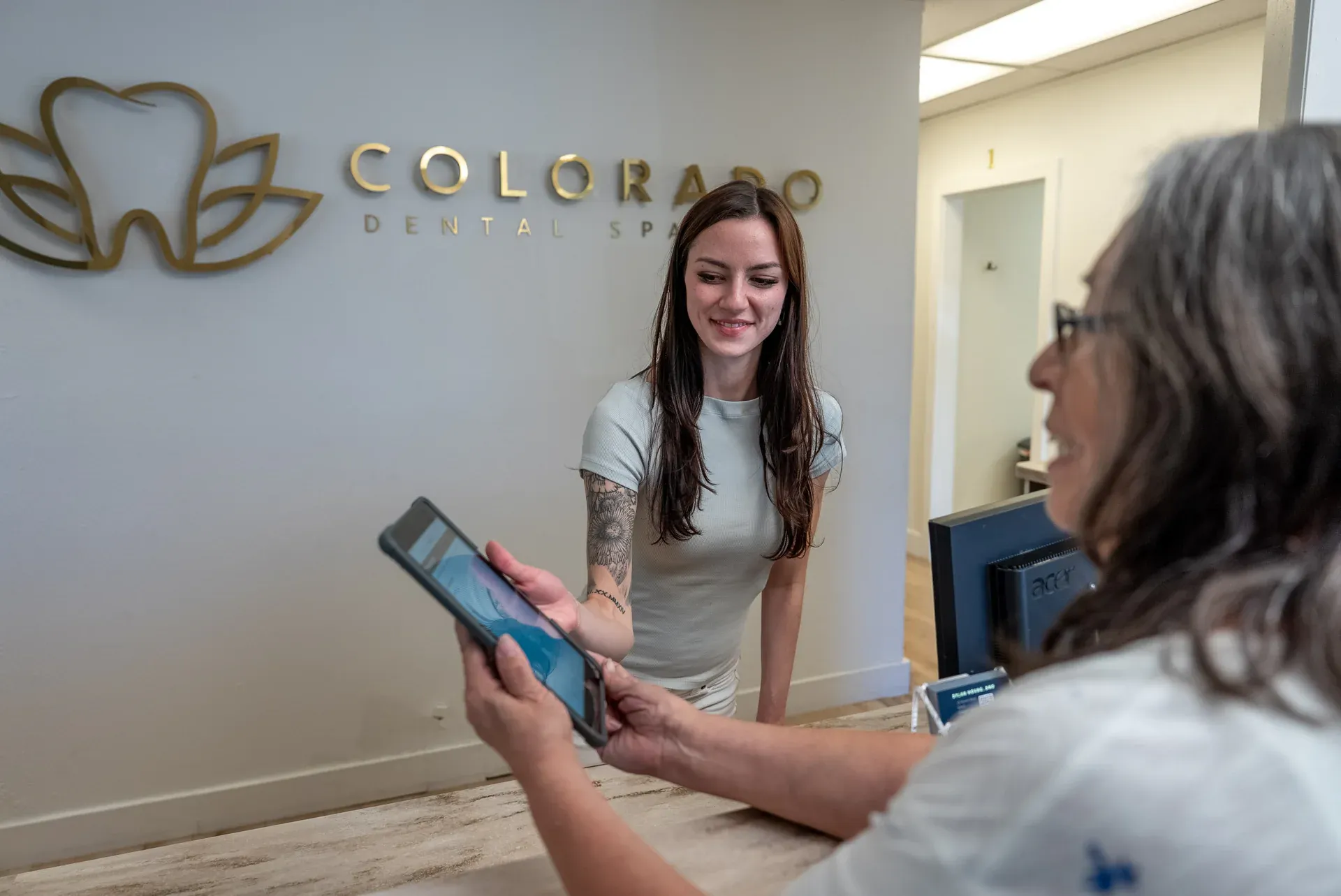 A Colorado Dental Spa team member reviewing a treatment estimate on a tablet with a patient in Golden, CO