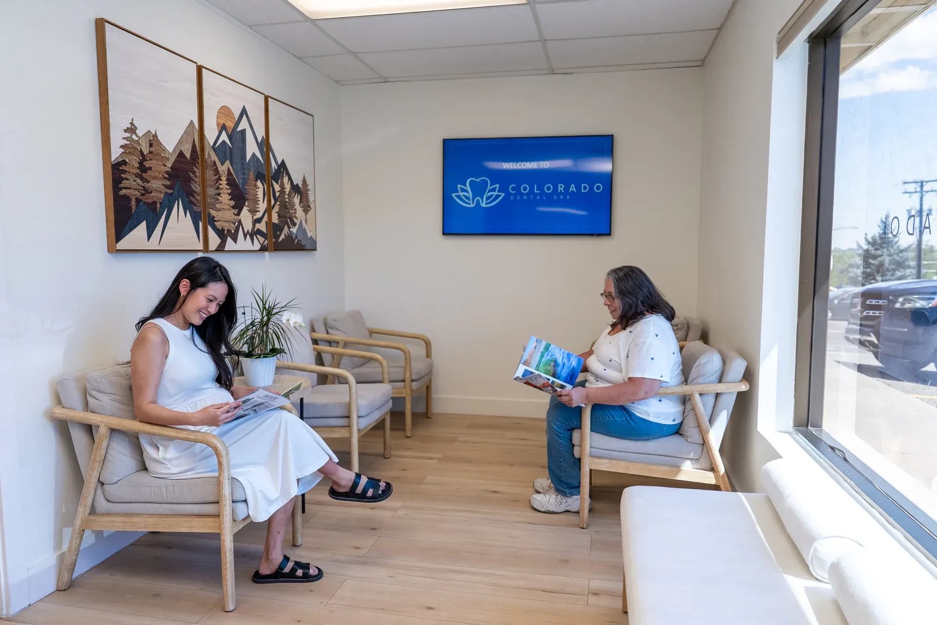 The calm reception lounge at Colorado Dental Spa in Golden, CO, with Colorado mountain artwork and natural light
