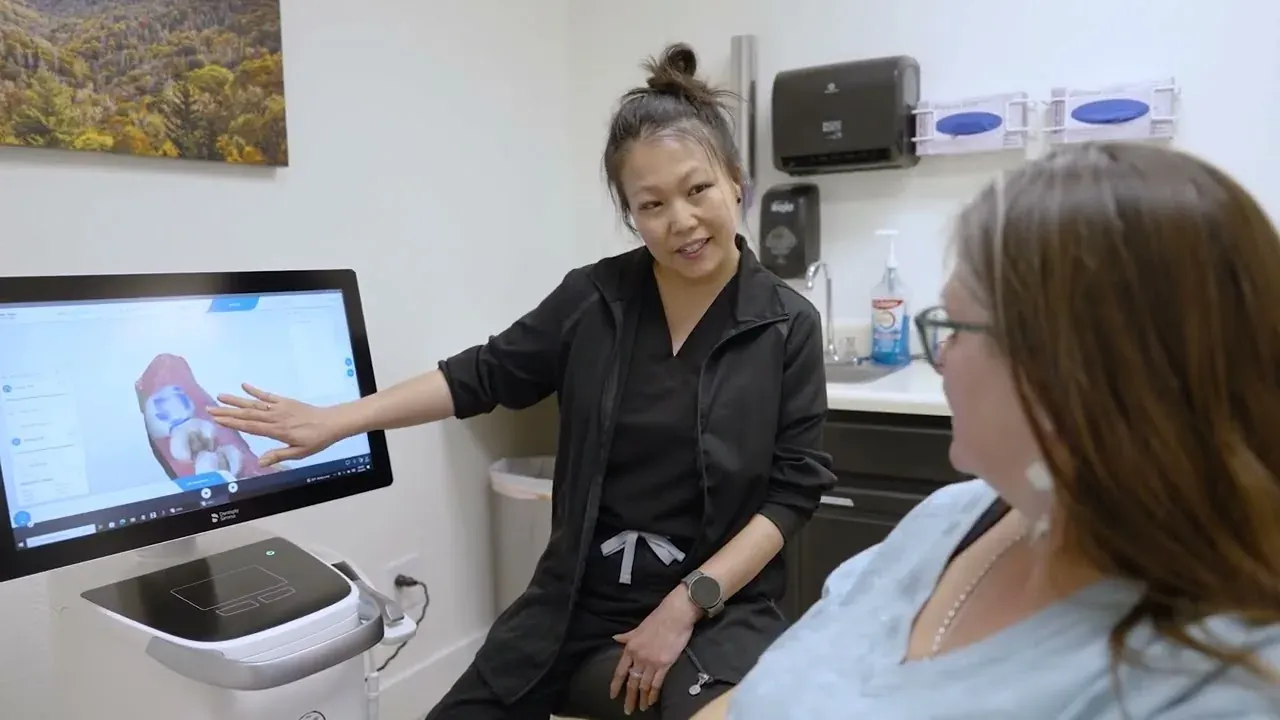 A Colorado Dental Spa team member reviewing an implant plan on screen with a patient in Golden, CO