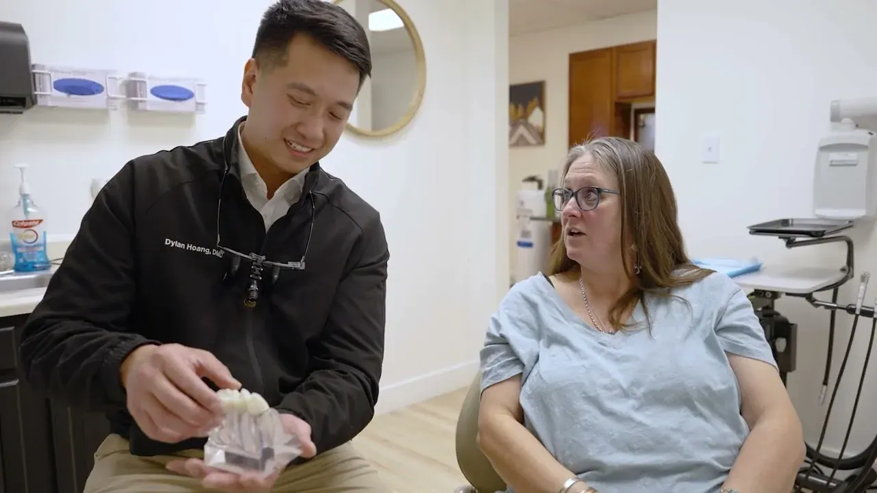 Dr. Dylan Hoang showing a patient a same-day ceramic crown at Colorado Dental Spa in Golden, CO
